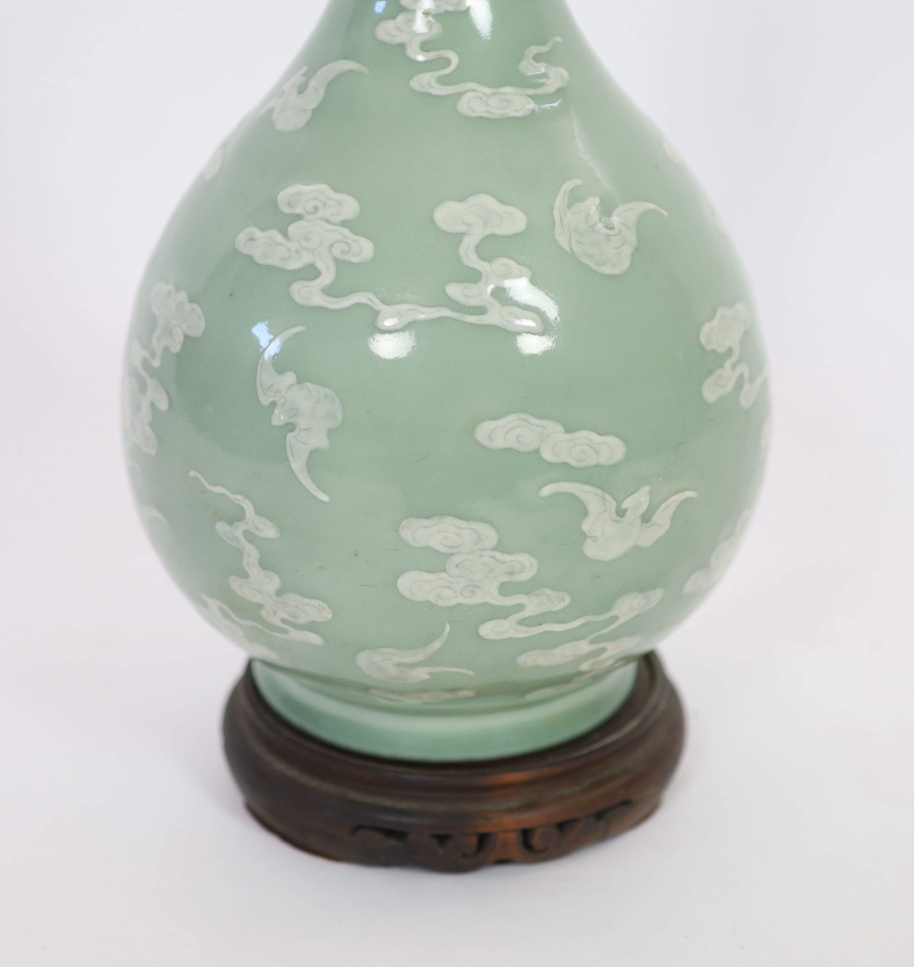 A Chinese celadon-glazed slip-decorated bottle vase, Qianlong seal mark and period (1736-95), Formerly mounted as a lamp with drilled hole through the seal mark and base.